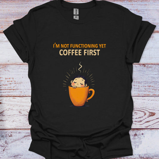 Black t-shirt with a coffee cup graphic and text on a wooden surface