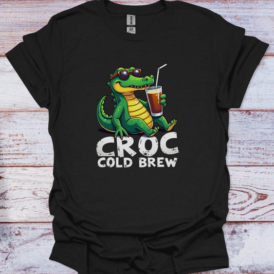 Black t-shirt with a crocodile holding a cup labeled 'Croc Cold Brew' on a wooden surface.