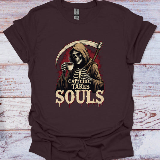 Brown t-shirt with a skeleton holding a coffee cup and 'Caffeine Takes Souls' text on a wooden surface.