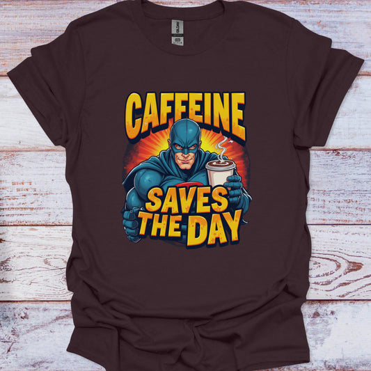 Brown t-shirt with superhero graphic and 'Caffeine Saves the Day' text on a wooden surface
