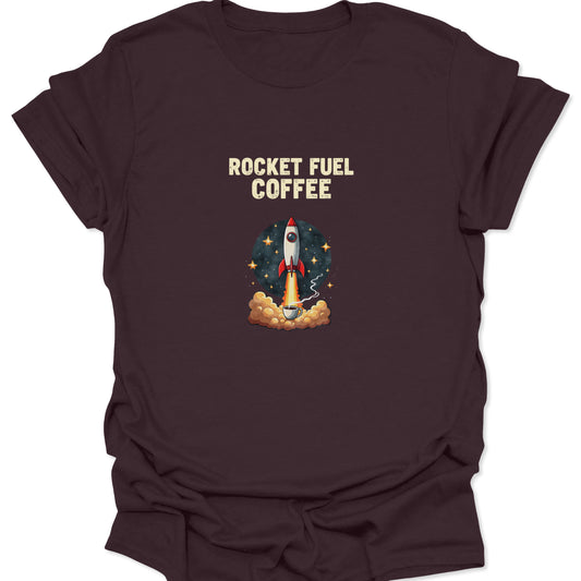 A dark chocolate brown t-shirt showing a retro rocket blasting off from a coffee mug, with cream-colored distressed text reading "ROCKET FUEL COFFEE" overhead.