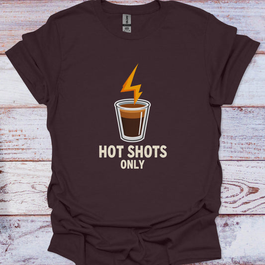 Brown t-shirt with a coffee cup graphic and 'Hot Shots Only' text on a wooden surface