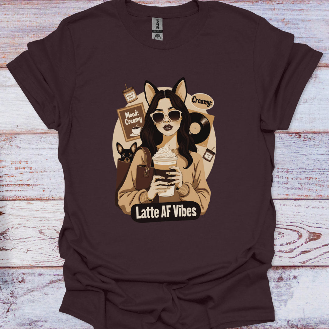 Brown t-shirt with a graphic of a person holding a coffee cup and text 'Latte AF Vibes' on a wooden surface.