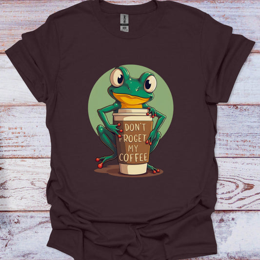 Brown t-shirt with a frog holding a coffee cup graphic on a wooden surface