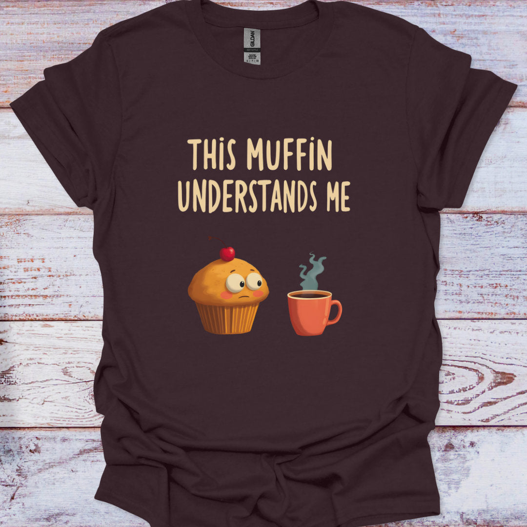 Brown t-shirt with a graphic of a muffin and coffee cup and text 'This Muffin Understands Me' on a wooden surface.