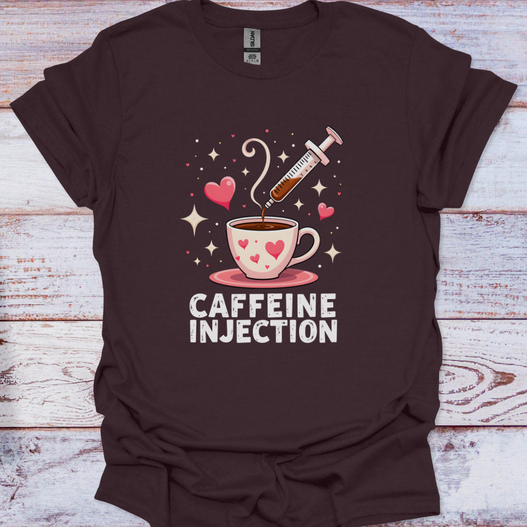Brown t-shirt with a graphic of a coffee cup and syringe labeled 'Caffeine Injection' on a wooden surface.