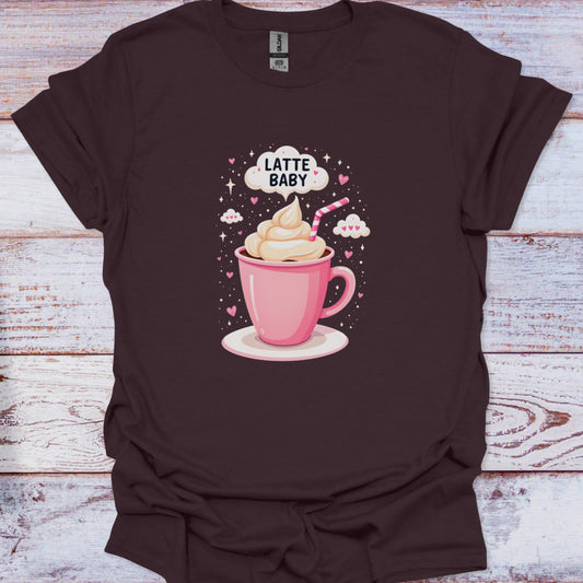 Brown t-shirt with a graphic of a pink cup of latte and 'Latte Baby' text on a wooden surface.