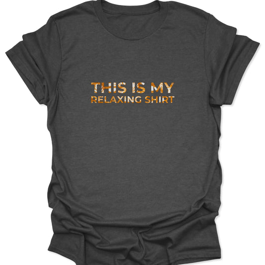 Dark heather gray shirt showing a minimalist graphic of the phrase "THIS IS MY RELAXING SHIRT" with a caramel-colored liquid swirl texture.