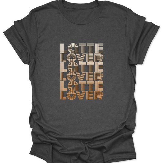 A dark heather gray t-shirt featuring a vertical stack of the text "Latte Lover" in a retro, multi-line font with a cream to amber gradient.