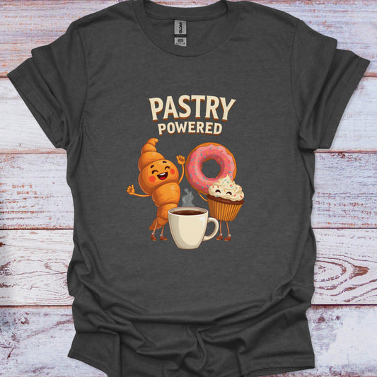 Dark gray t-shirt with cartoon characters and 'Pastry Powered' text on a wooden surface