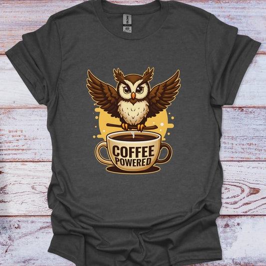 Dark gray t-shirt with an owl on a coffee cup graphic and 'Coffee Powered' text, on a wooden surface.