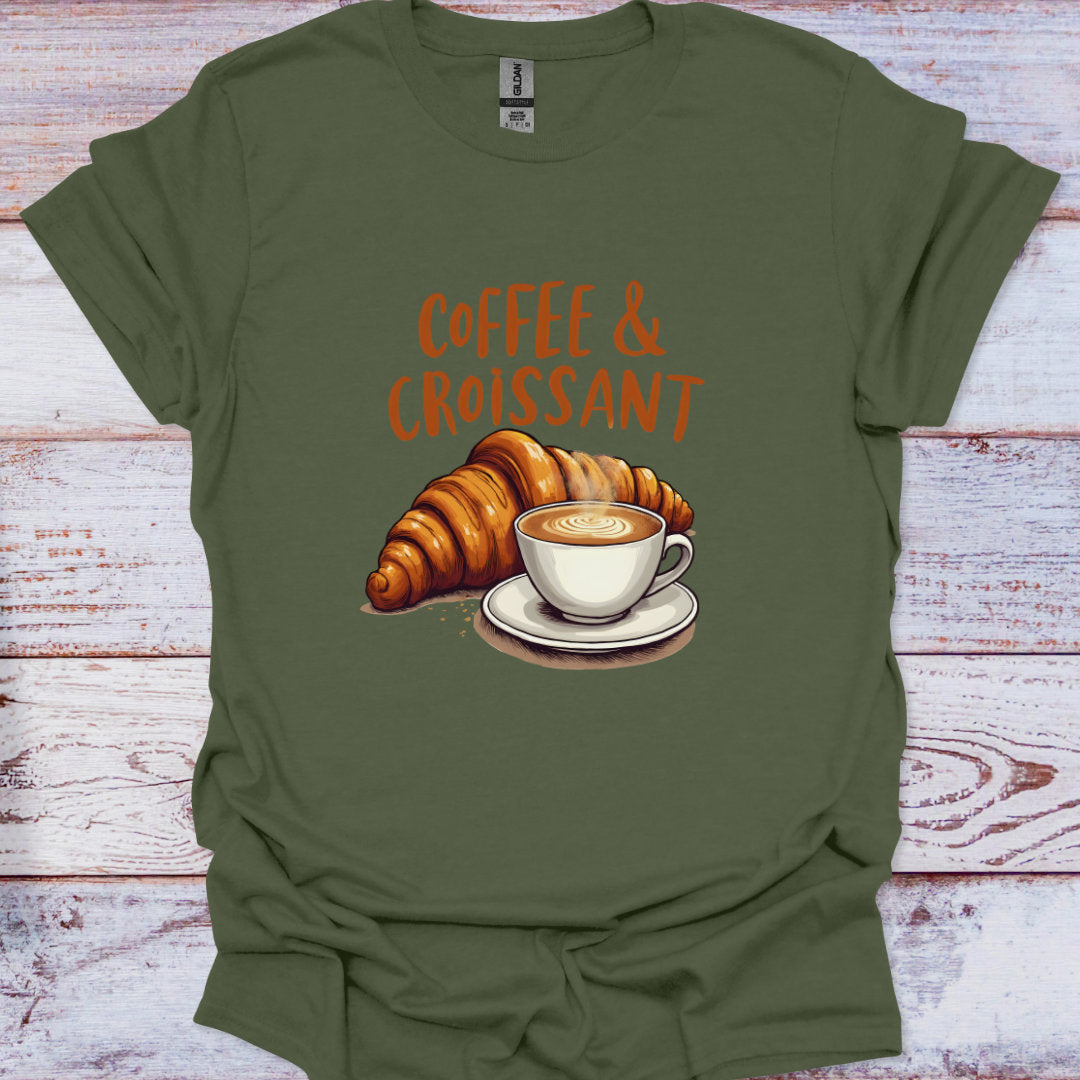Green t-shirt with 'Coffee & Croissant' design on a wooden surface