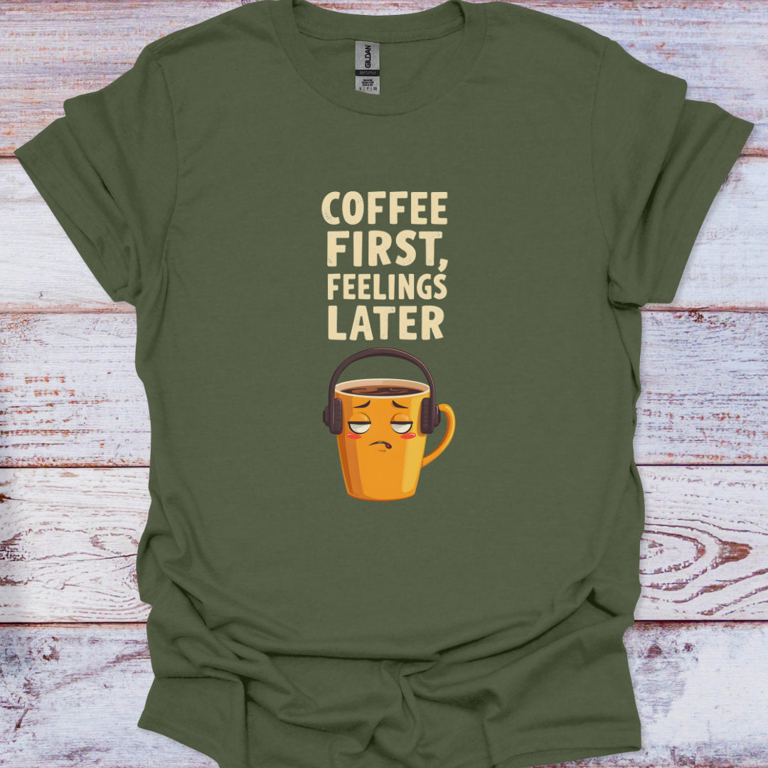 Green t-shirt with a coffee cup graphic and text 'Coffee First, Feelings Later' on a wooden surface.