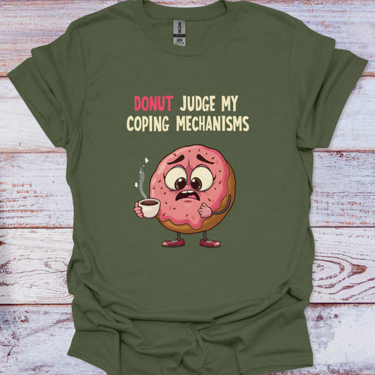 Green t-shirt with a cartoon donut holding coffee and text 'Donut Judge My Coping Mechanisms' on a wooden surface.