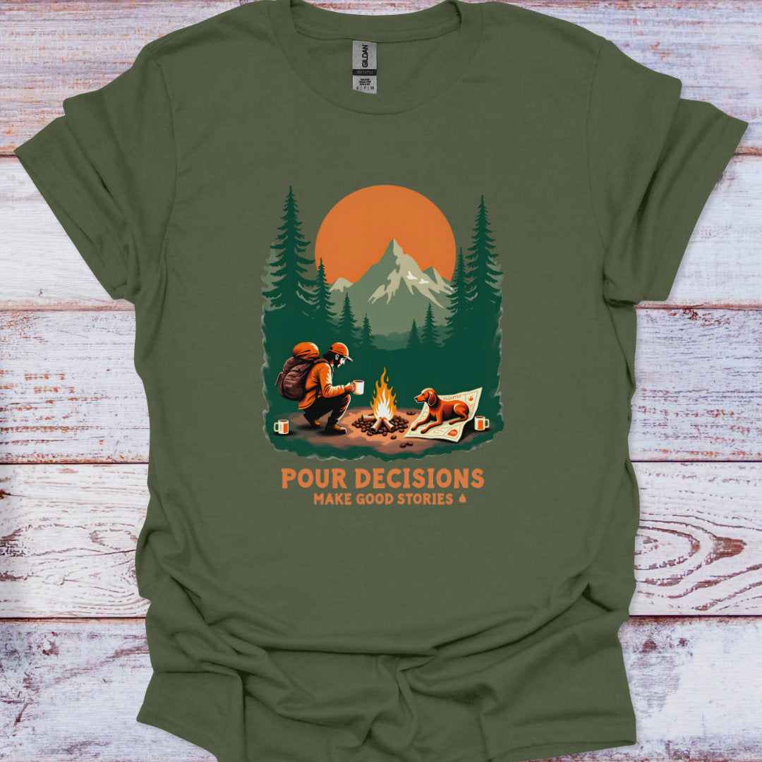Green t-shirt with a graphic of a man and his dog by a campfire and mountains, with text 'Pour Decisions Make Good Stories &'.