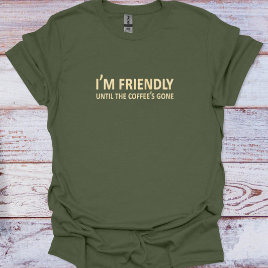 Green t-shirt with text 'I'm Friendly Until the Coffee's Gone' on a wooden surface