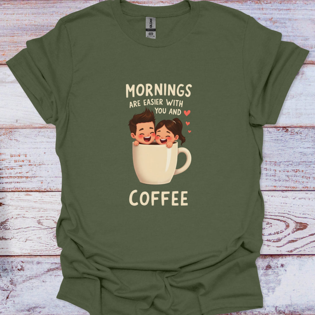 Green t-shirt with cartoon design and text 'Mornings are easier with you and coffee' on a wooden surface.
