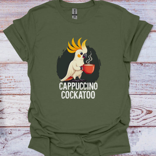 Green t-shirt with a cartoon cockatoo holding a cup of coffee and 'Cappuccino Cockatoo' text on a wooden surface.