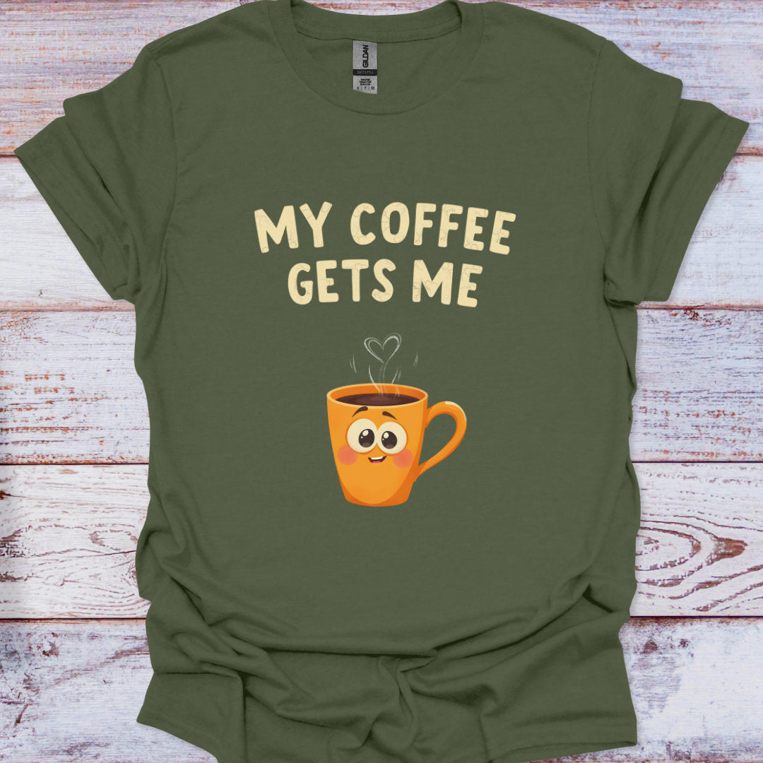 Green t-shirt with a cartoon coffee mug and text 'My Coffee Gets Me' on a wooden surface