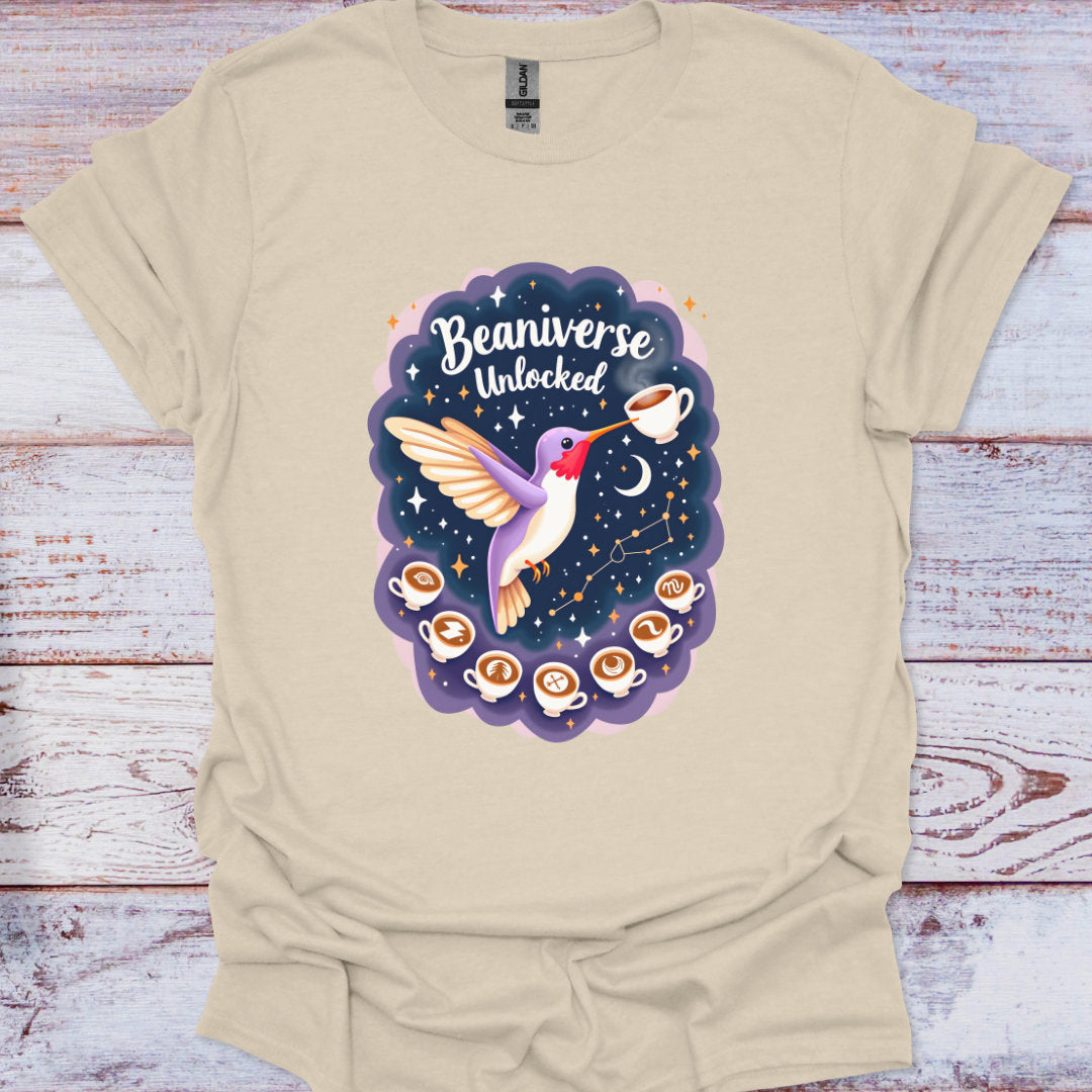 Beige t-shirt with a colorful graphic of a hummingbird and coffee cups on a wooden surface