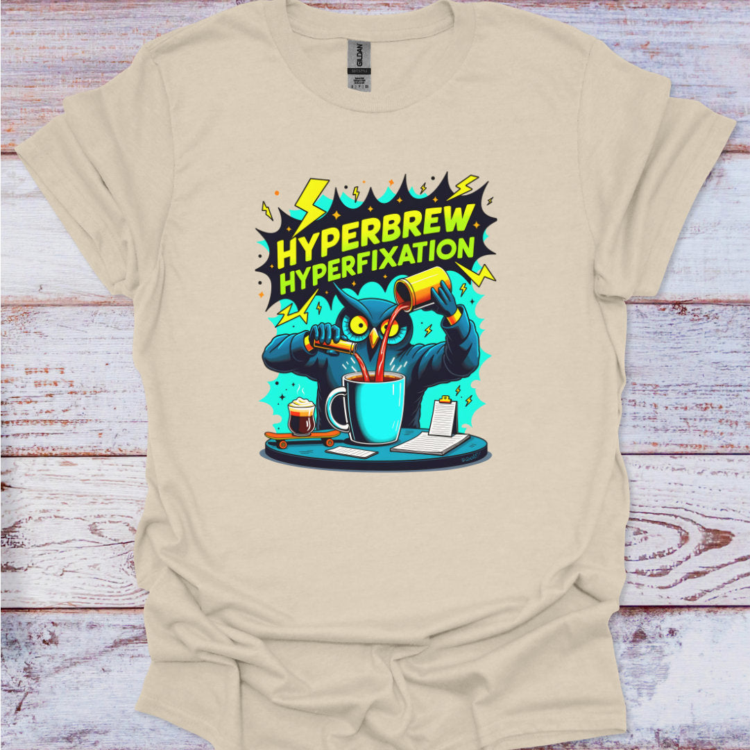 Beige t-shirt with a graphic design of a cartoon owl and coffee cup on a wooden surface