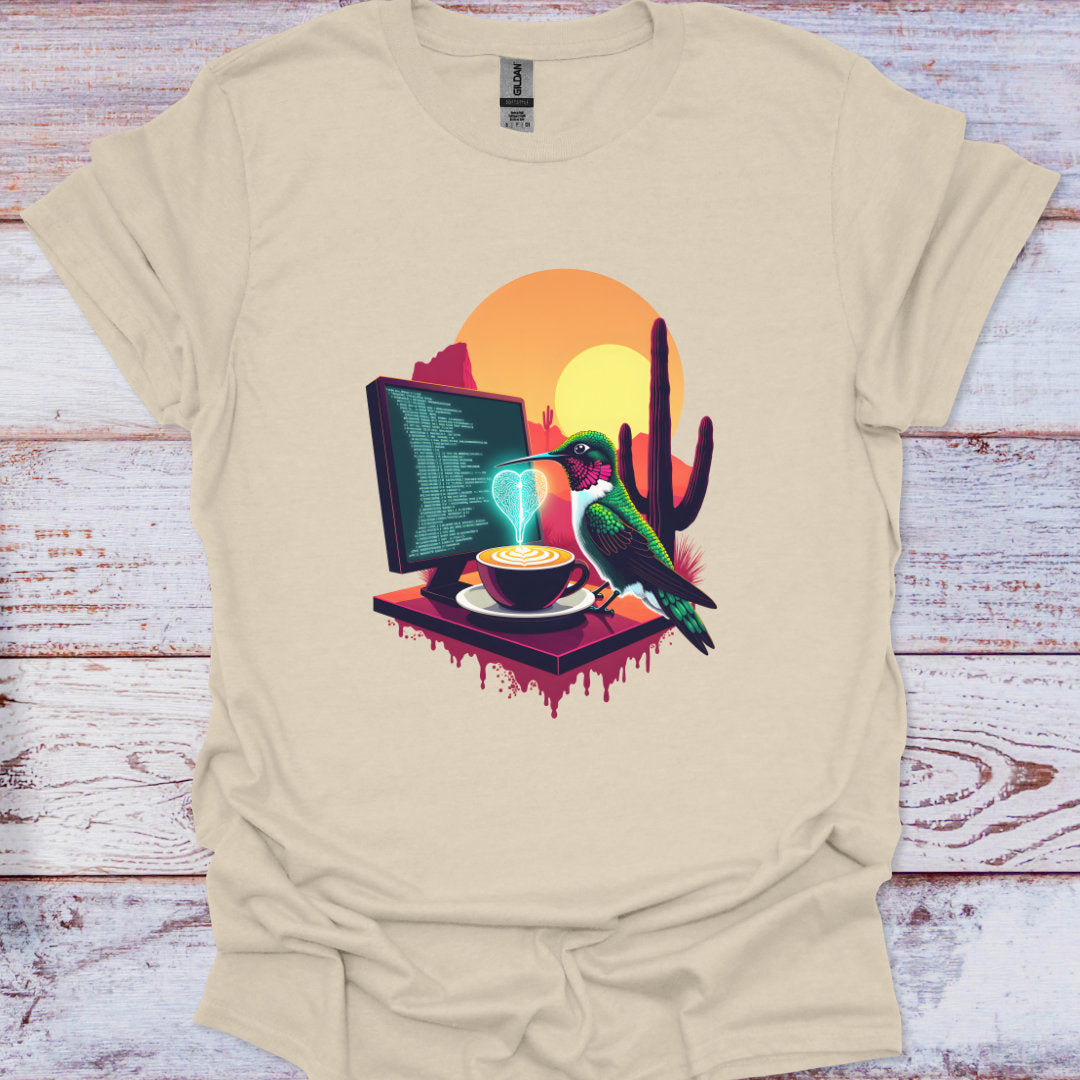 Beige t-shirt with a colorful graphic of a computer, coffee cup, and bird on a wooden surface