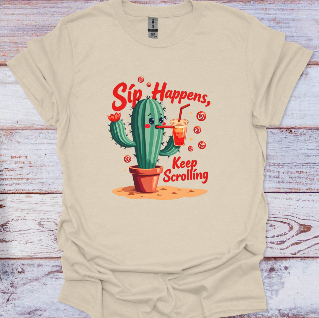 Beige t-shirt with a cactus graphic and text 'Sip Happens, Keep Scrolling' on a wooden surface.
