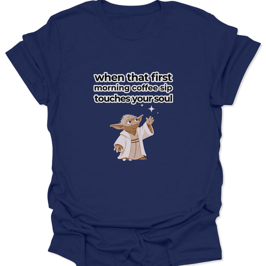 A navy blue t-shirt with a high-contrast white text design and a small Yoda character illustration celebrating the first sip of coffee.