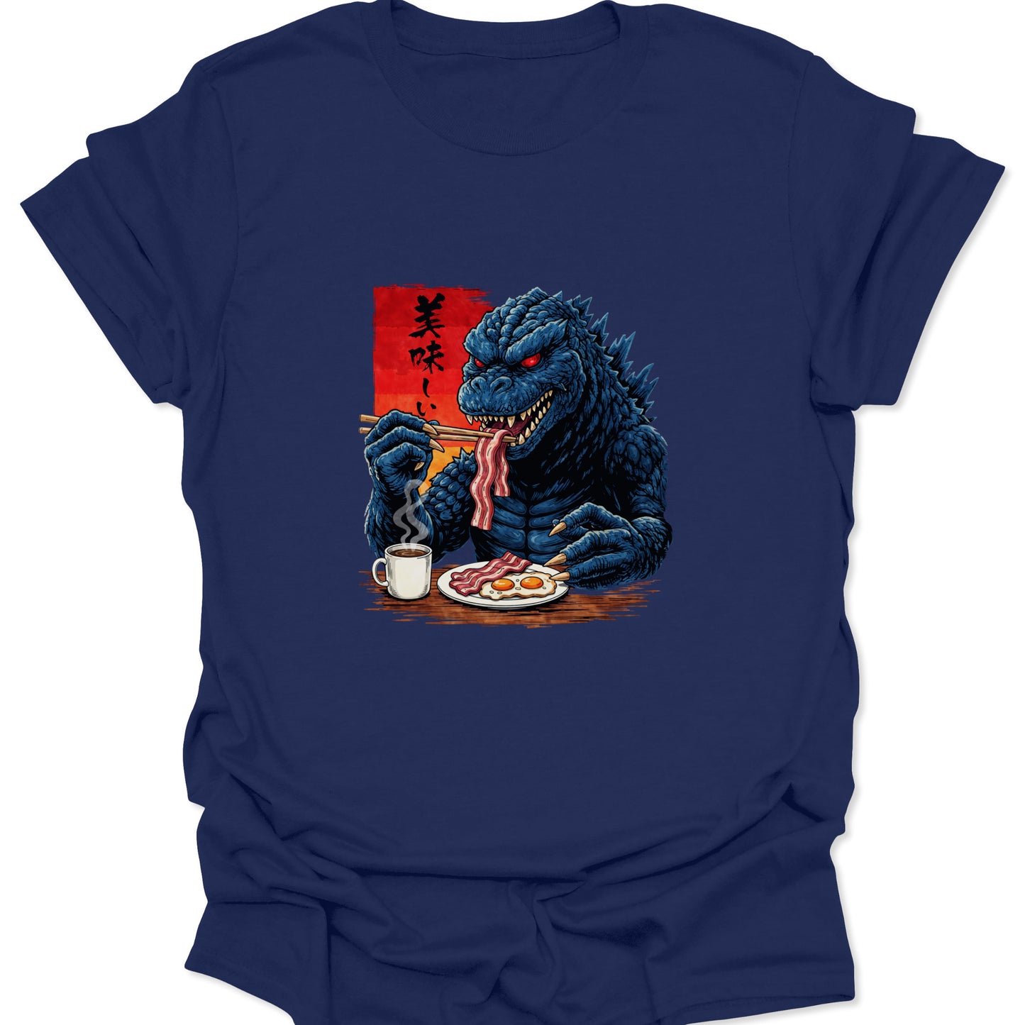 Graphic tee on a navy blue fabric featuring a blue scaly monster eating breakfast with chopsticks and a mug of coffee.