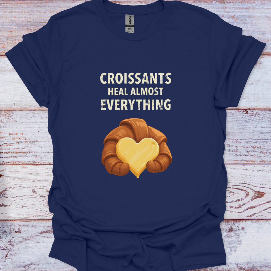 Navy blue t-shirt with a croissant graphic and text on a wooden surface