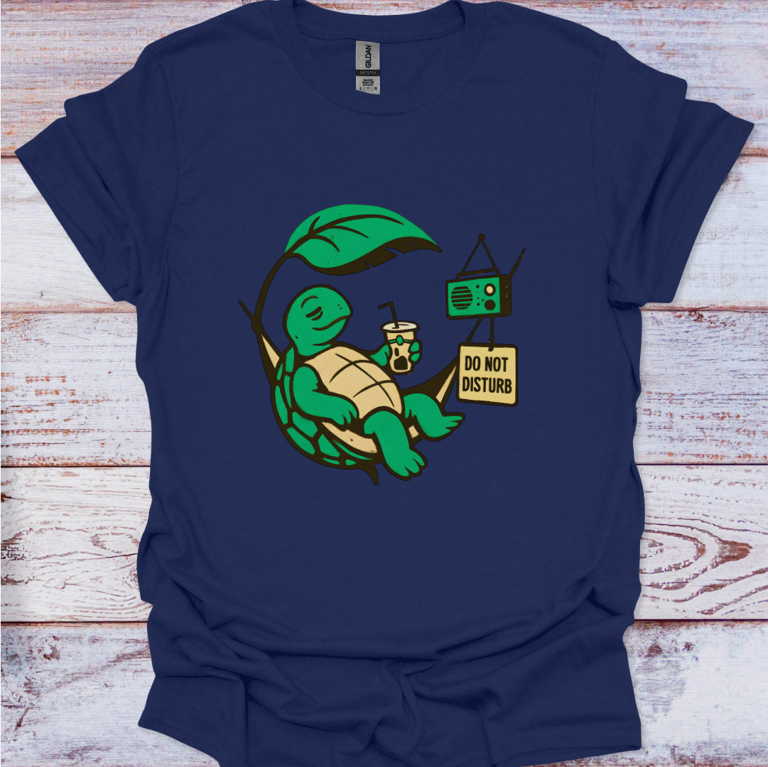 Navy blue t-shirt with a green turtle graphic and 'Do Not Disturb' sign on a wooden surface