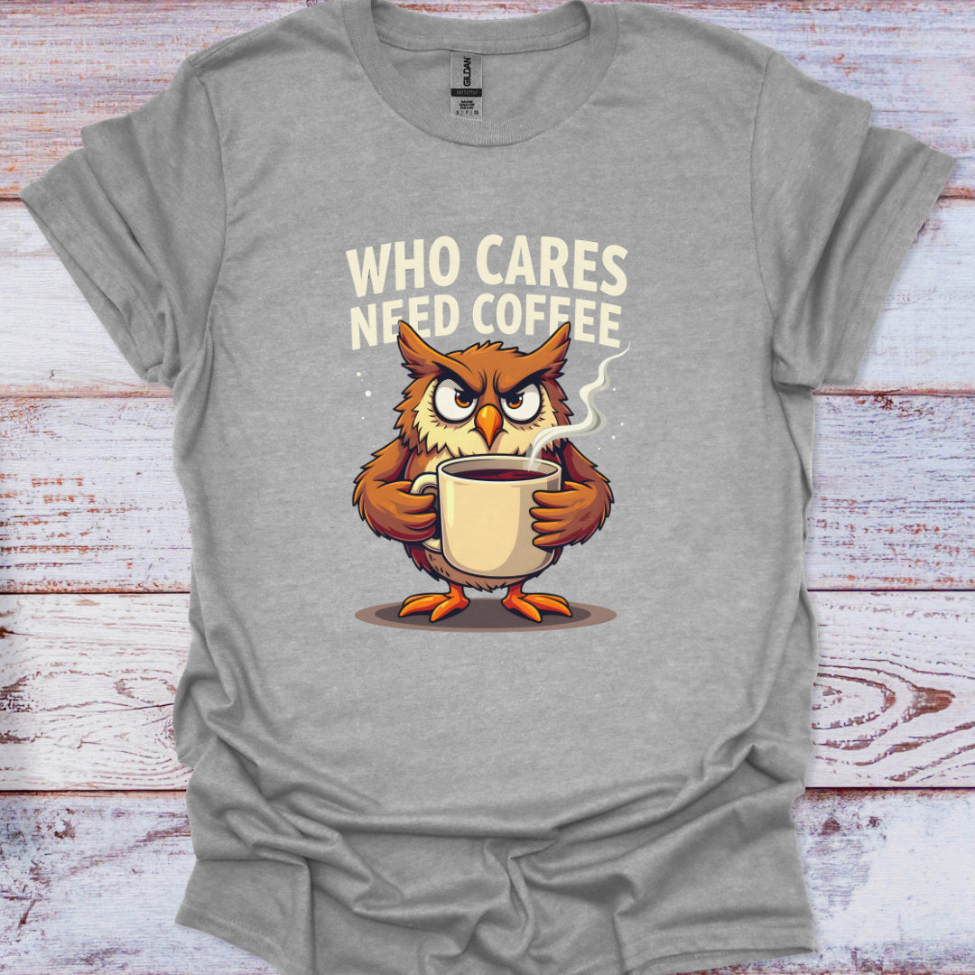 Gray t-shirt with an owl holding a coffee cup and text 'WHO CARES NEED COFFEE' on a wooden surface.