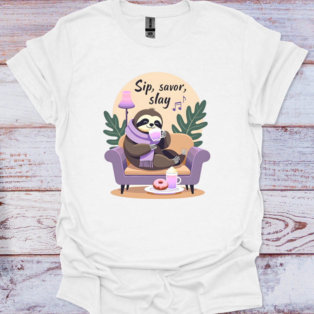 White t-shirt with a sloth graphic and 'Sip, savor, slay' text on a wooden surface