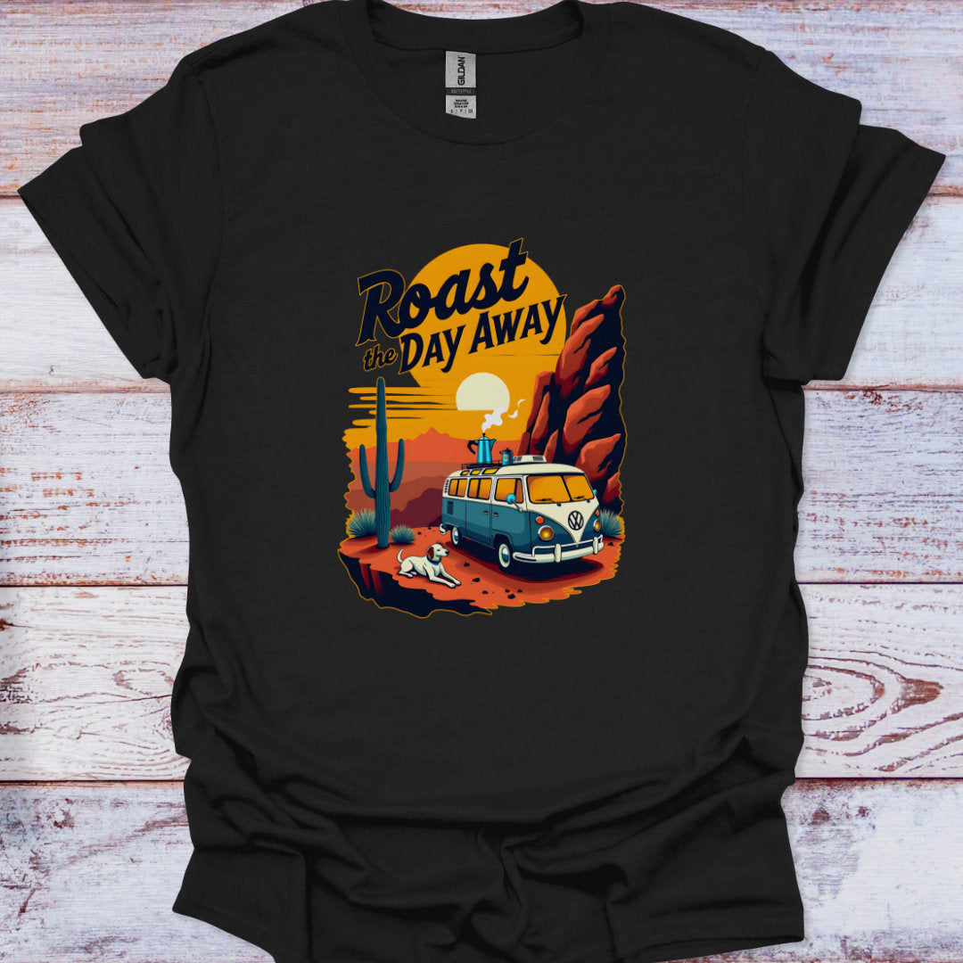Black t-shirt with a graphic design of a van, cactus, and sunset text 'Roast the Day Away' on a wooden surface.