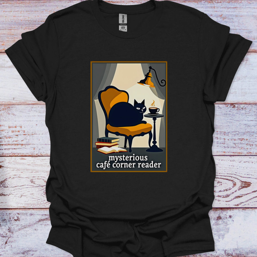 Black t-shirt with a graphic of a cat in a cafe and text 'mysterious cafe corner reader' on a wooden surface.