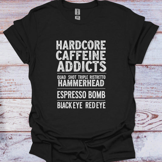 Black t-shirt with white text listing coffee-related terms on a wooden surface