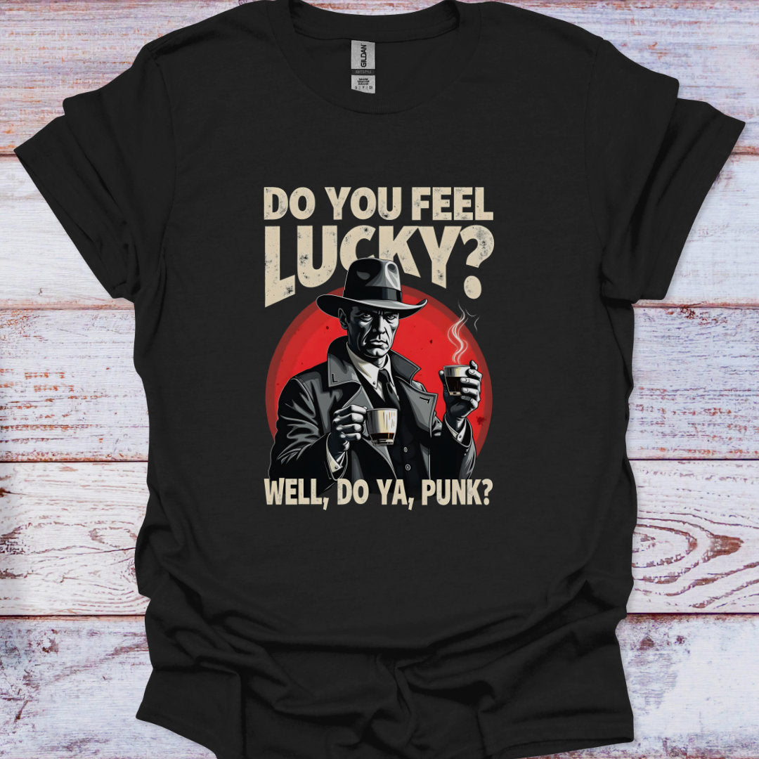 Black t-shirt with a graphic of a man holding a cup and text 'Do you feel lucky? Well, do ya, punk?' on a wooden surface.