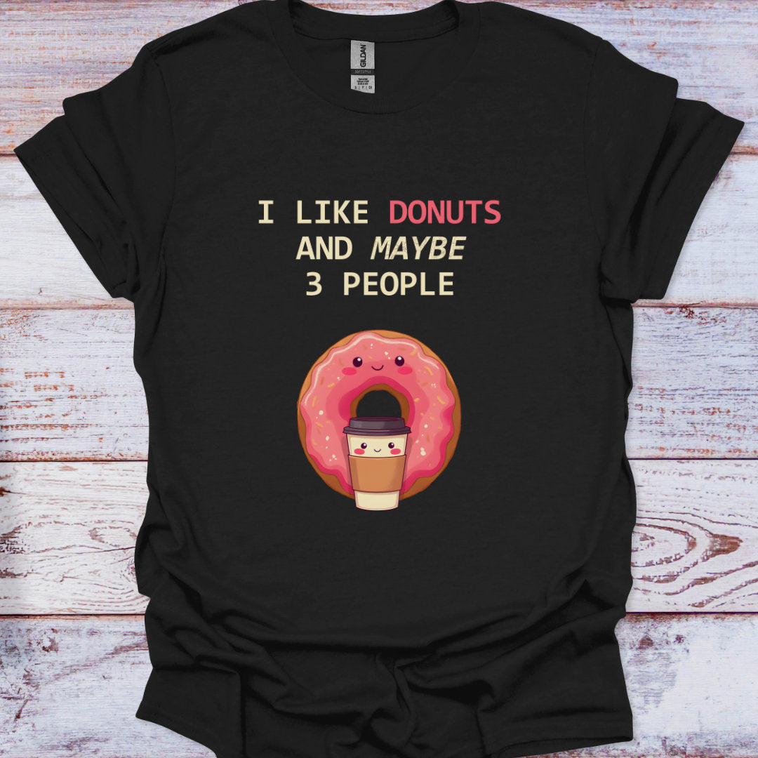 Black t-shirt with a cartoon donut and text on a wooden surface