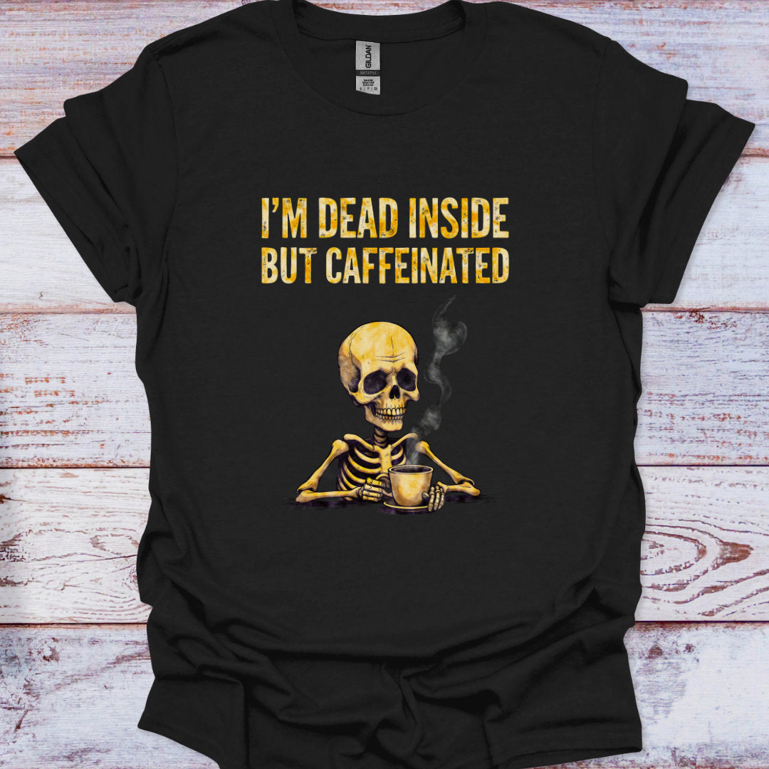 Black t-shirt with a skeleton holding a coffee cup and text 'I'm dead inside but caffeinated' on a wooden surface.