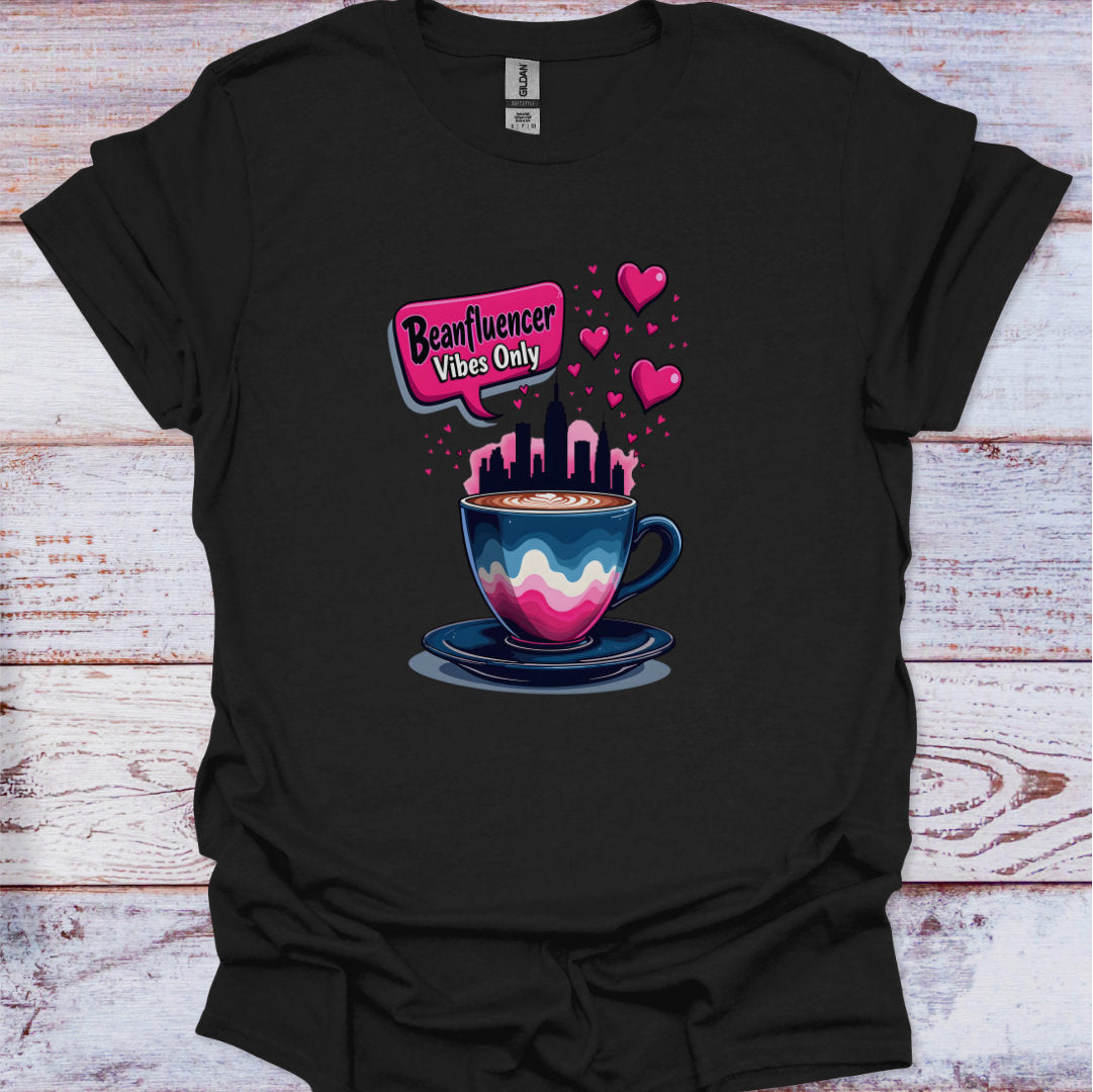 Black t-shirt with a colorful coffee cup graphic and 'Beanfluencer Vibes Only' text on a wooden surface.