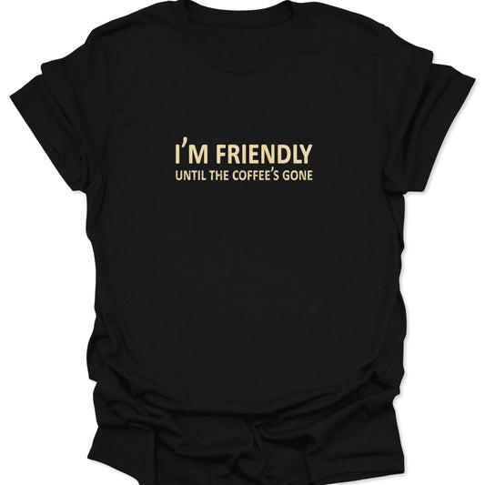 A black graphic t-shirt featuring the text "I'M FRIENDLY UNTIL THE COFFEE'S GONE" in bold, vintage cream-colored typography centered on the chest.