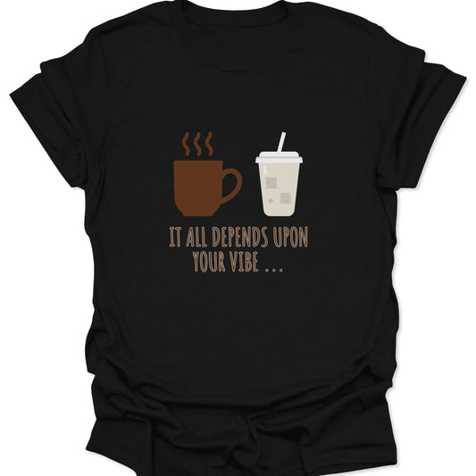 Graphic tee on a black fabric featuring a brown steaming coffee mug and a light beige iced coffee cup with the text "IT ALL DEPENDS UPON YOUR VIBE..." in thin brown lettering.