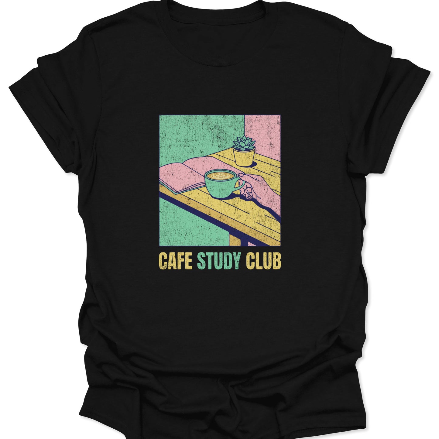 Graphic tee on a black fabric background featuring a retro pastel illustration of a hand holding a coffee cup next to an open book and a potted succulent.