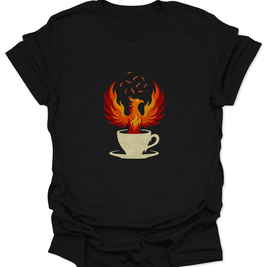 Graphic tee on a black fabric background featuring a vibrant red and orange phoenix rising from a cream-colored coffee cup with dark coffee beans floating above.