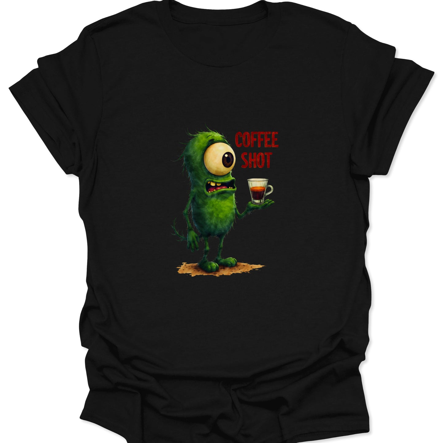 Close-up of a green, cyclops monster in distress, clutching a small espresso shot, with the text "COFFEE SHOT" on a black t-shirt.