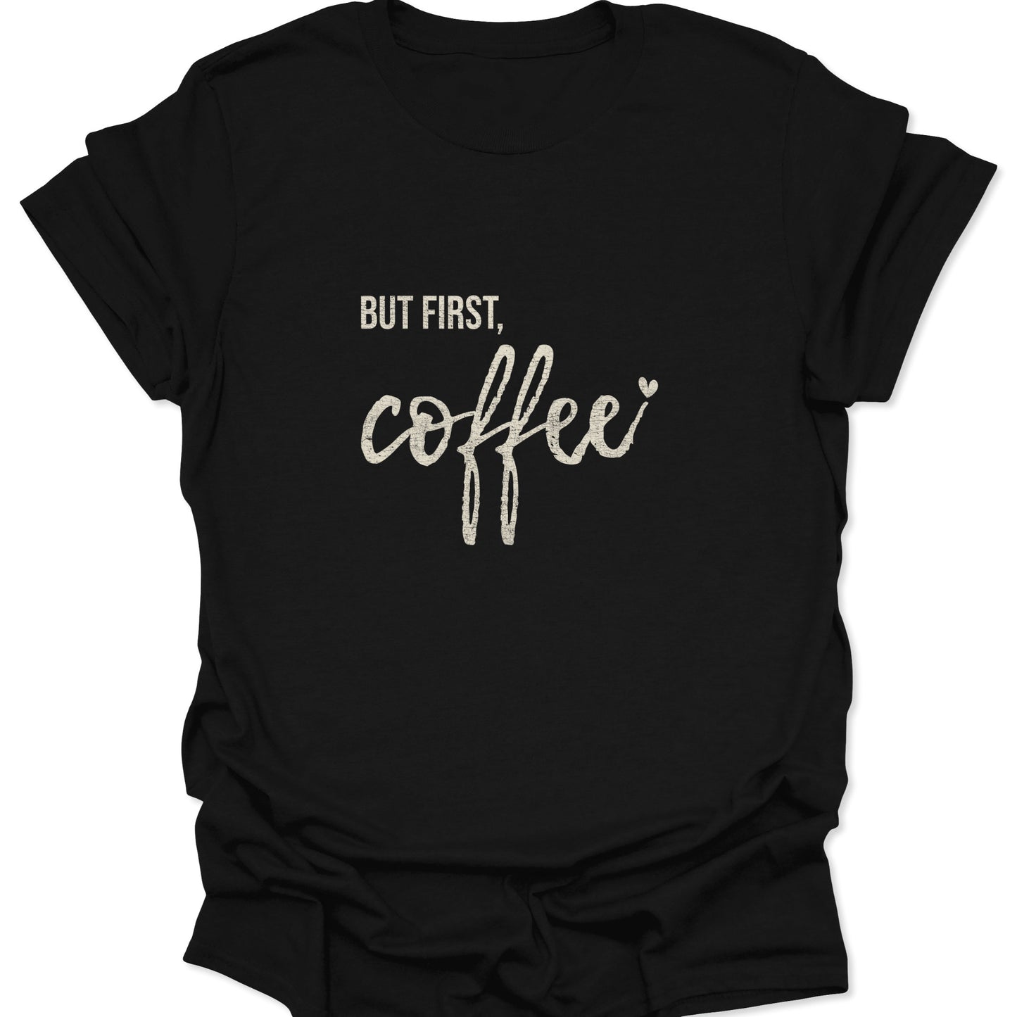 A black graphic t-shirt featuring the words "BUT FIRST, coffee" in white distressed block and script lettering with a small heart accent.