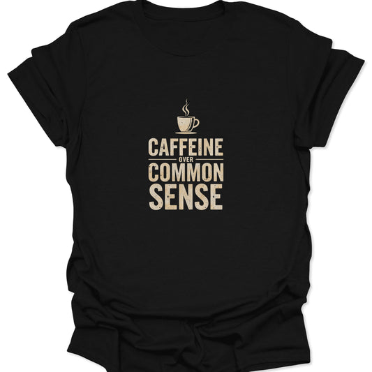 Flat lay of black t-shirt featuring beige distressed text reading "Caffeine Over Common Sense" with a coffee cup icon.