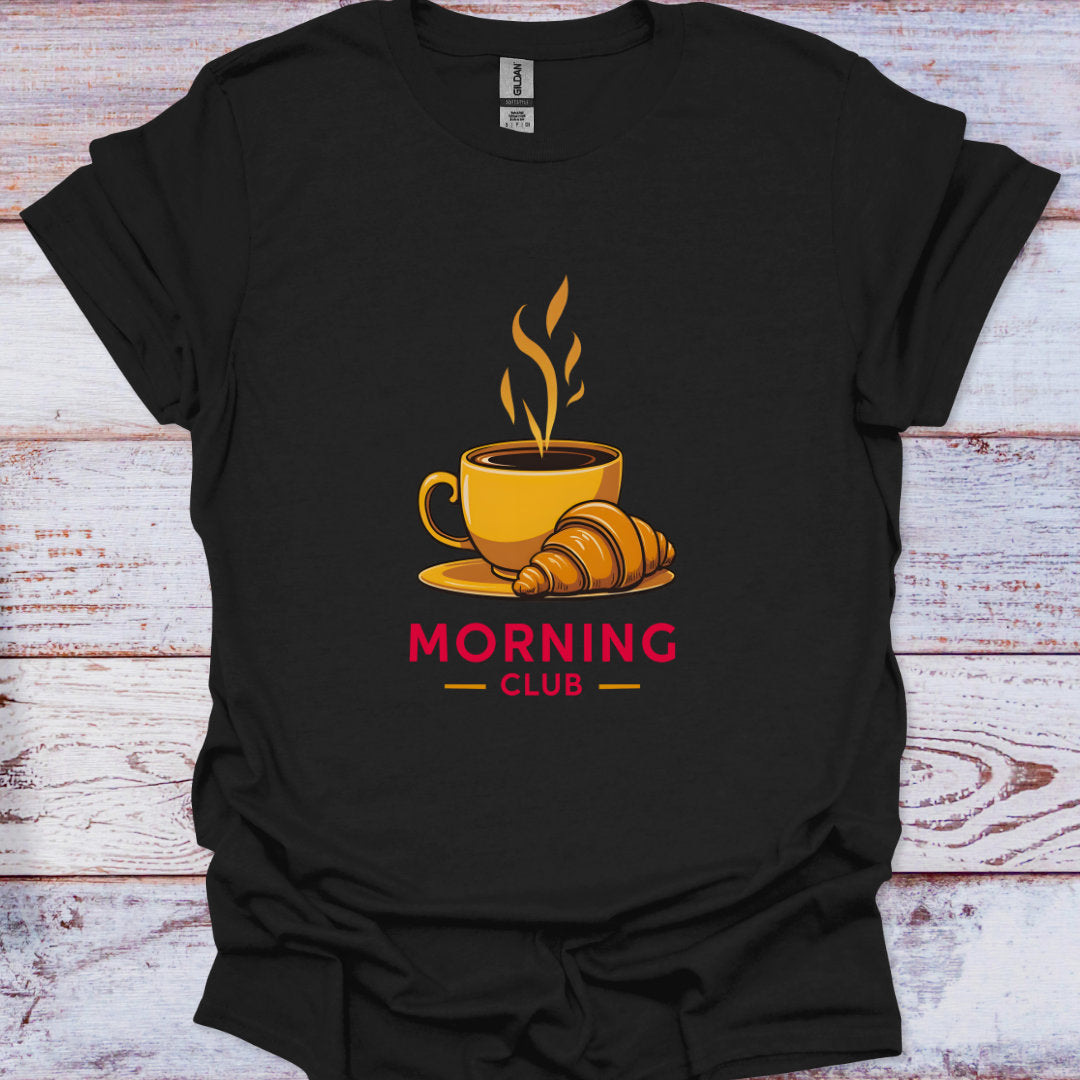 Black t-shirt with a coffee cup and croissant graphic and 'Morning Club' text on a wooden surface.