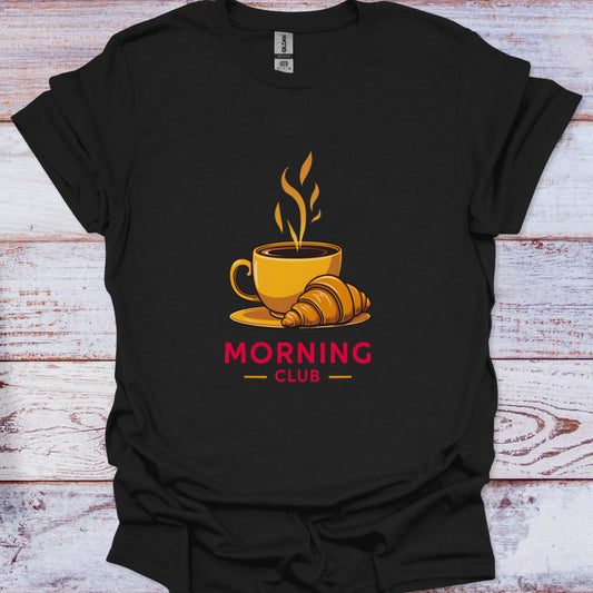 Black t-shirt with a coffee cup and croissant graphic and 'Morning Club' text on a wooden surface.