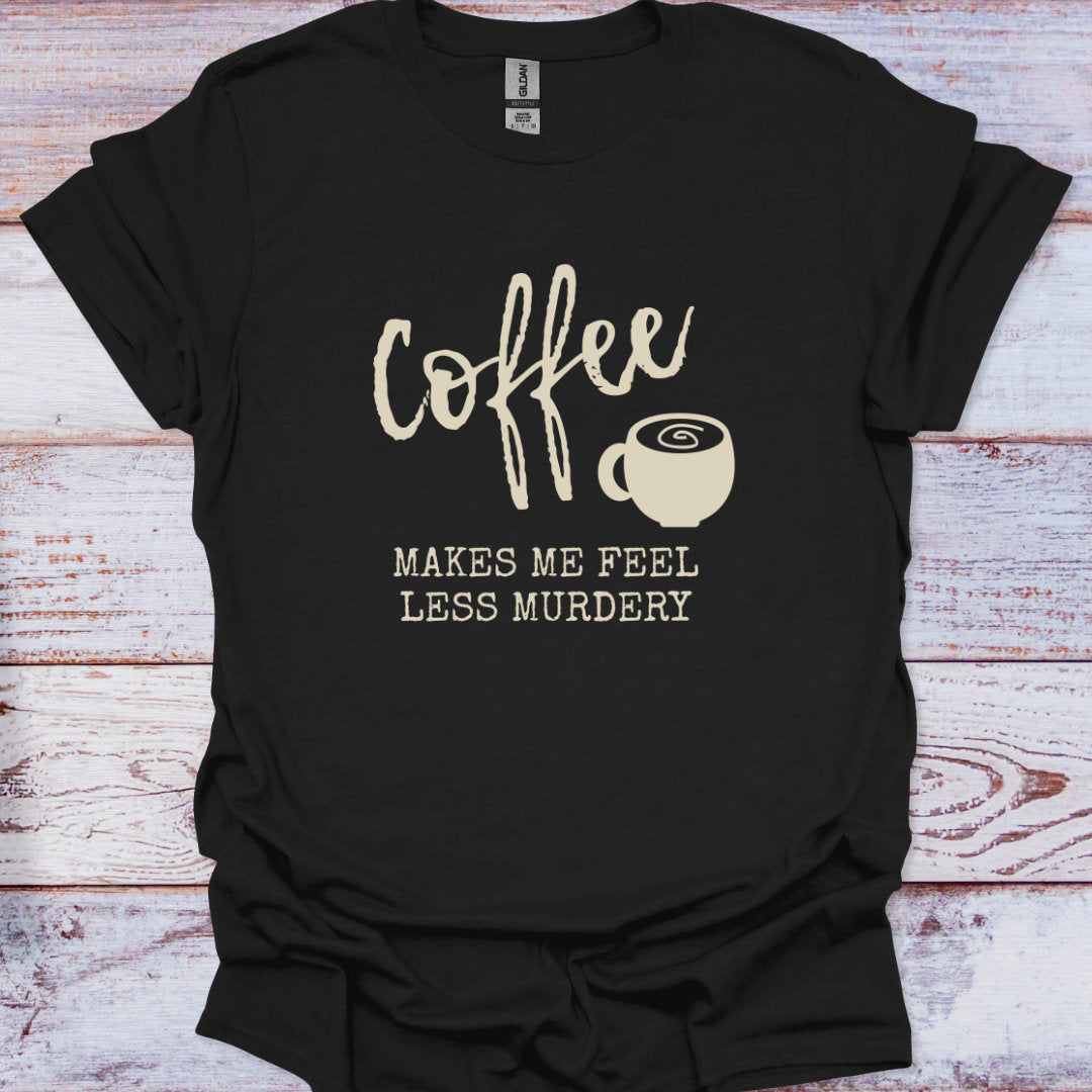 Black t-shirt with 'Coffee makes me feel less murdery' text and coffee cup graphic on a wooden surface
